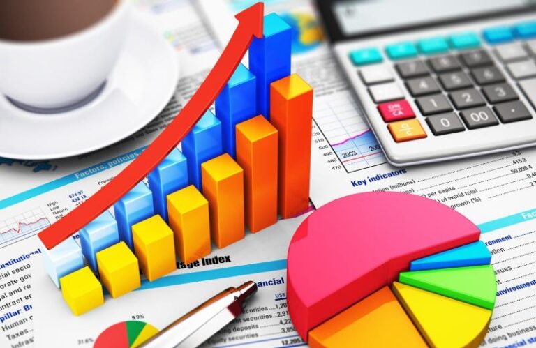 Mesa com calculadora, canetas, papéis e gráficos