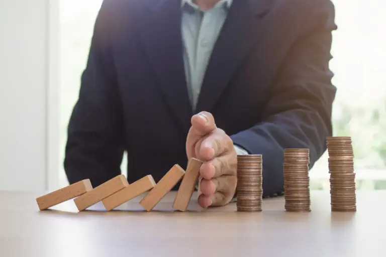 Comparação entre agiotagem e factoring representada por dominós e pilhas de moedas