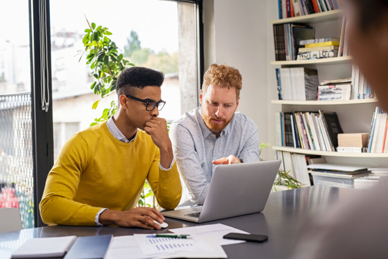 Dois homens usando um computador.