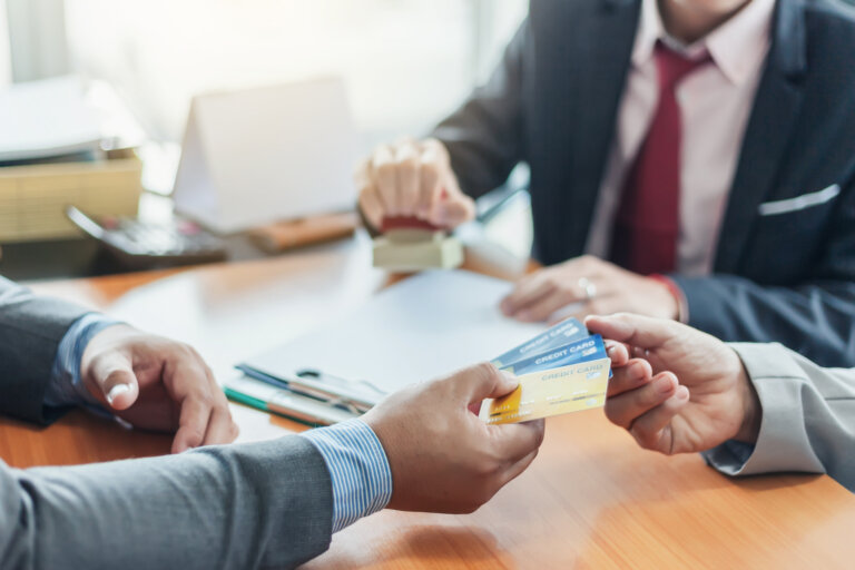 Empresários segurando cartão de crédito.