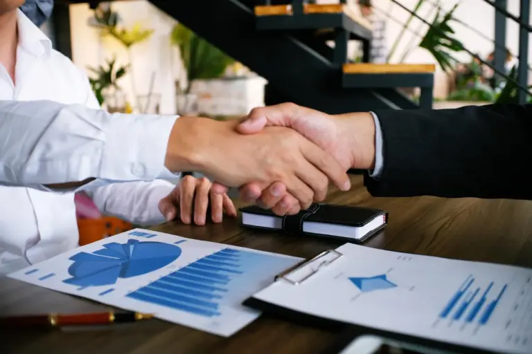 Cedente e sacado representados por aperto de mãos em acordo financeiro com documentos sobre a mesa