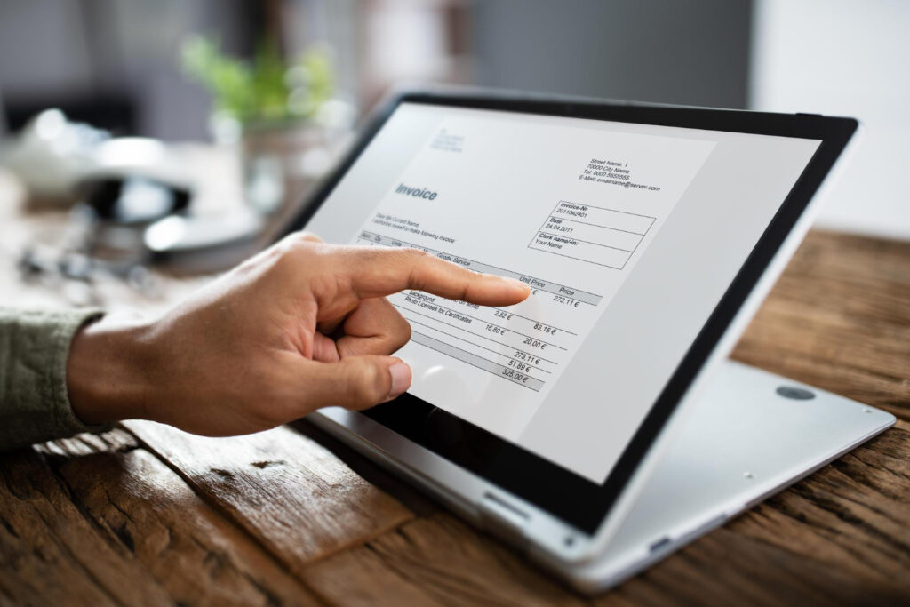 Nota fiscal eletrônica Pessoa apontando para tela de tablet exibindo nota fiscal eletrônica com itens e valores detalhados
