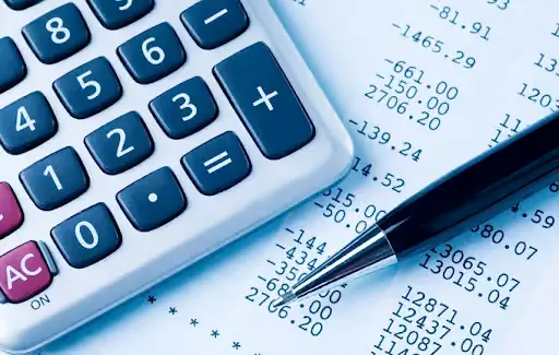 Extrato financeiro sendo analisado com calculadora para verificar cobrança indevida