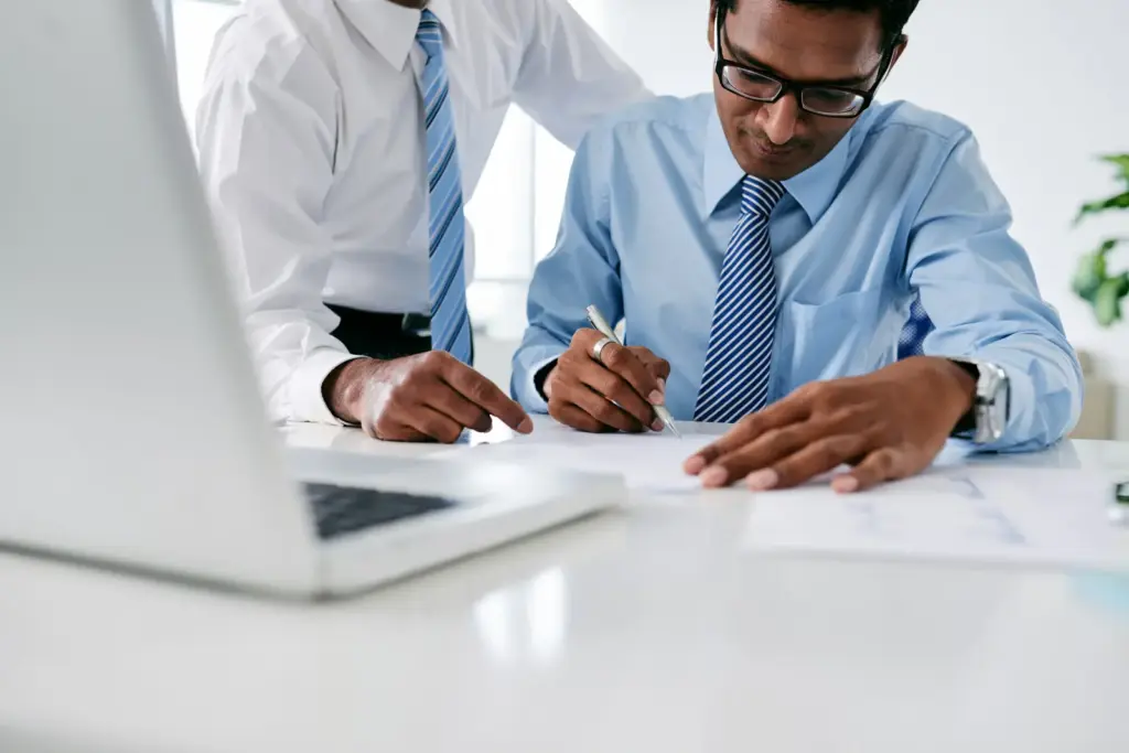 Executivos assinando documentos durante formalização de contrato de factoring