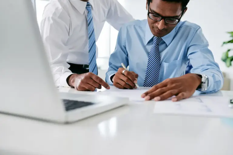 Executivos assinando documentos durante formalização de contrato de factoring