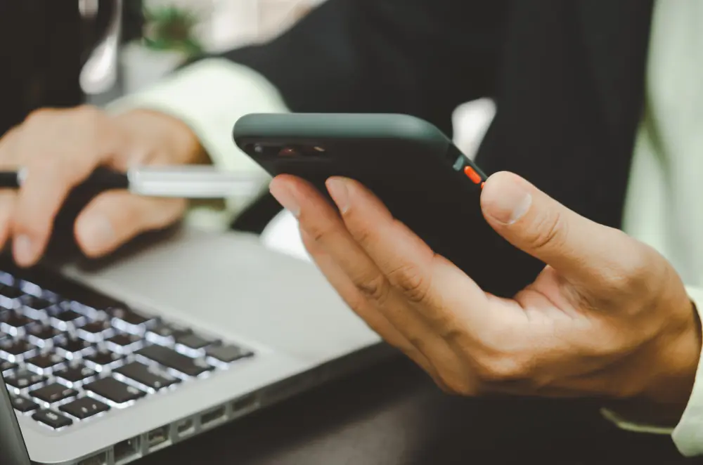 Mensagens de cobrança pelo WhatsApp Profissional enviando mensagens de cobrança pelo WhatsApp usando celular e notebook