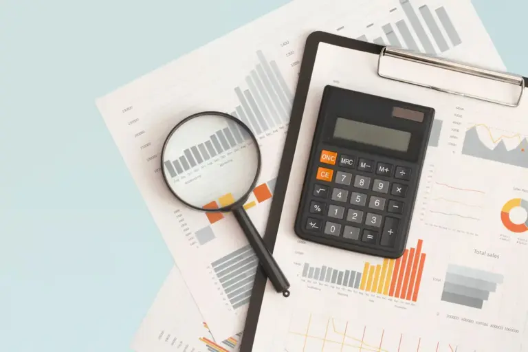 Lupa e calculadora sobre relatórios financeiros, representando a análise de debêntures conversíveis.